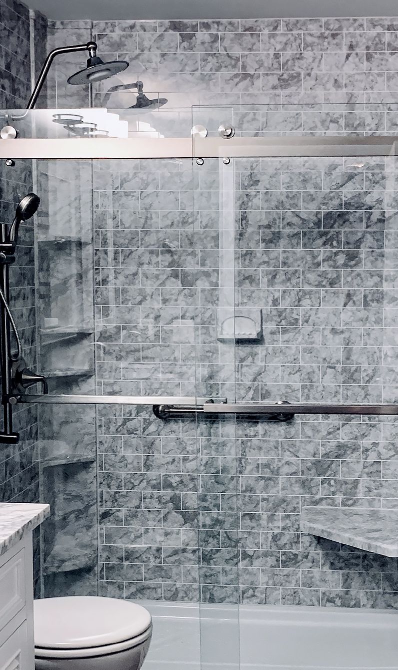 glass door shower with tile wall