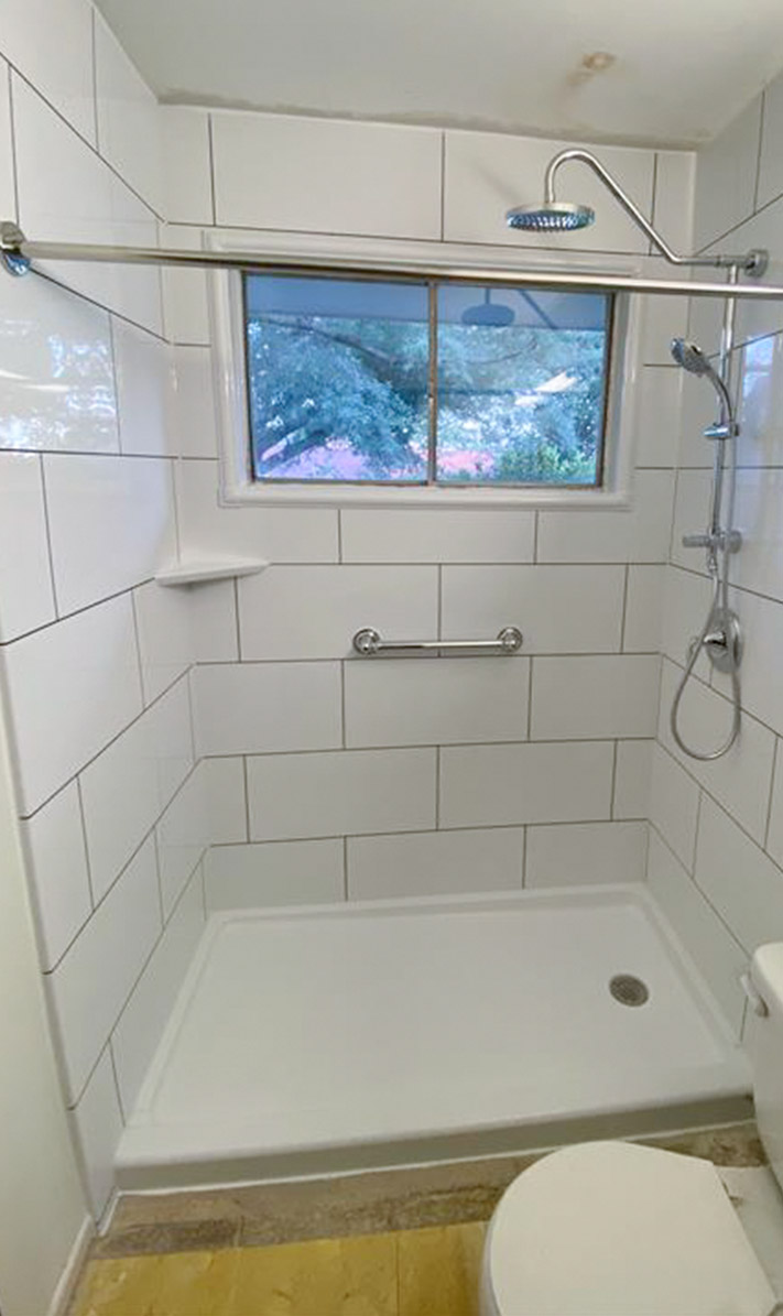 newly remodeled white-tiled shower