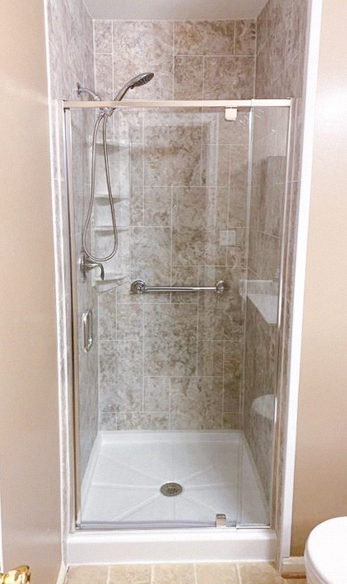 newly remodeled shower with mottled brown tile