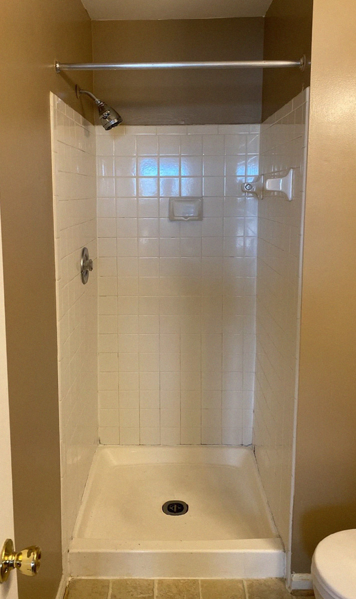 before photo of white-tiled shower