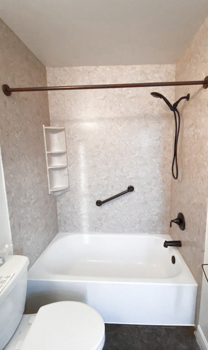 renovated half-bath with mottled cream tile and black accents