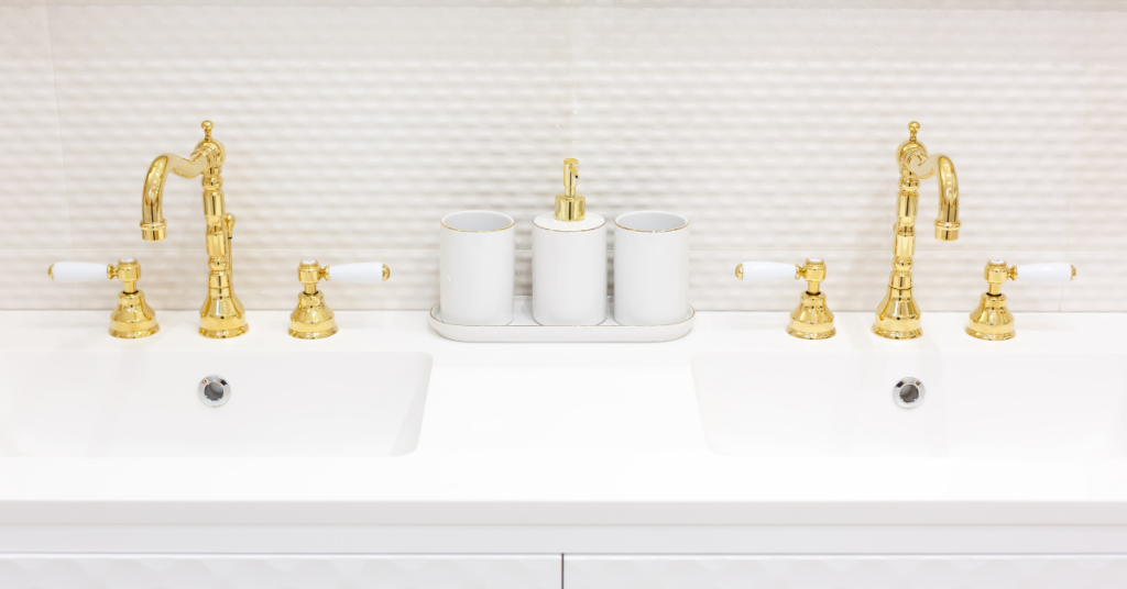 white bathroom counters with gold bathroom fixtures